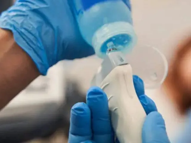 Gloved physician’s hands preparing an ultrasound probe
